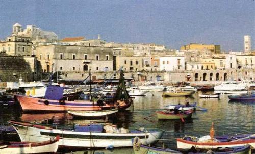 a group of boats in a harbor with buildings at Palazzo Lupicini Affittacamere in Bisceglie