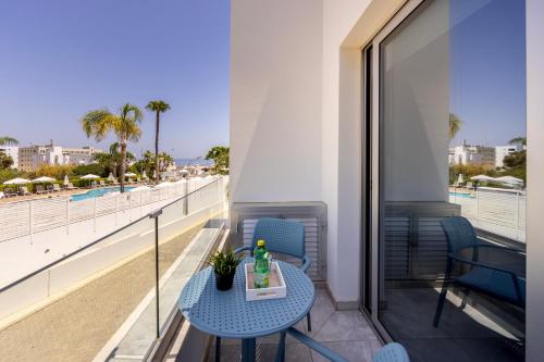 a table on a balcony with a view of the beach at Fig Tree Bay Residences 1 Lantiana Villa in Protaras