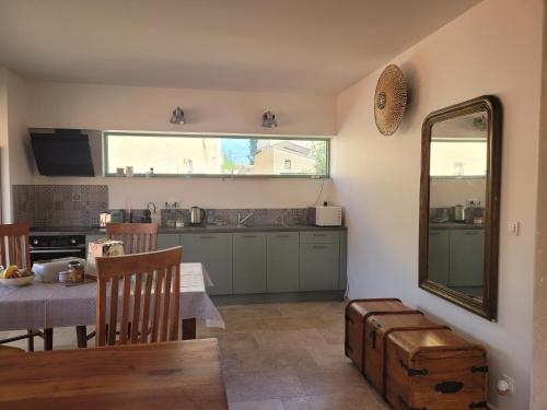 a kitchen and dining room with a table and a mirror at Gîte l'atelier de Phil et Delfe in Sainte-Cécile-les-Vignes