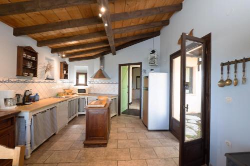 a kitchen with white counters and wooden ceilings at Villa Manavra in Ýpsos