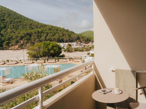 a balcony with a view of a beach and mountains at Hyde Ibiza in Cala Llonga