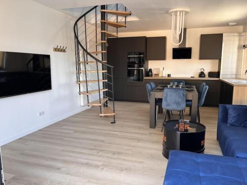 un salon avec une table et un escalier en colimaçon dans l'établissement Maison au Pays de Fontainebleau, à Vulaines-sur-Seine