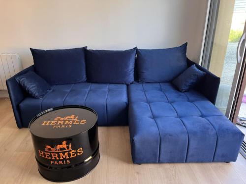 a blue couch in a living room with a hat at Maison au Pays de Fontainebleau in Vulaines-sur-Seine
