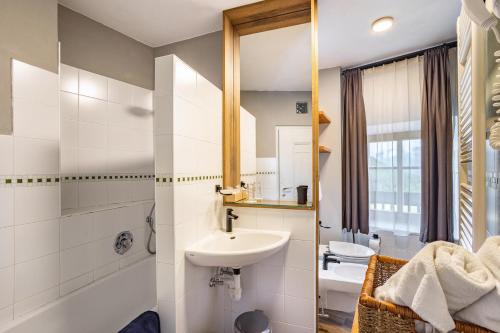 IssengoにあるResidence Grünbacherの洗面台と鏡のある白いバスルーム