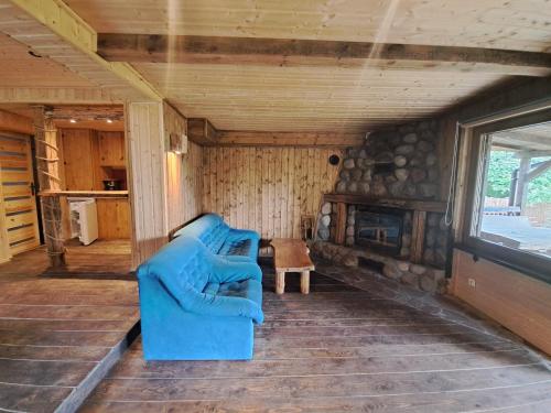 a living room with a blue couch and a fireplace at Siedlisko nad Jeziorem-Mazury in Mrągowo