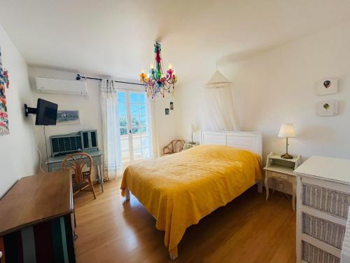 une chambre avec un lit avec une couverture jaune dans l'établissement Villa Piscine CALVI, à Calvi