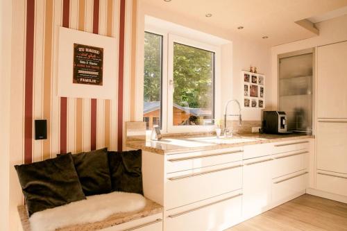 トロイスドルフにあるIdyllische Familien-Oaseの白いキャビネット、シンク、窓付きのキッチン