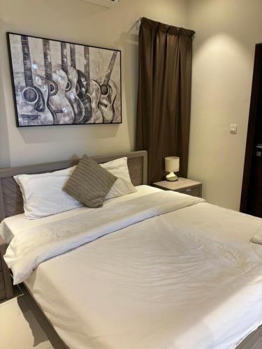 a bedroom with a large bed with white sheets at Hawana Salalah Resort - Acacia 7 in Ţāqah