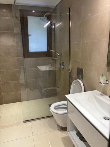 a bathroom with a shower and a toilet and a sink at Hawana Salalah Resort - Acacia 7 in Ţāqah