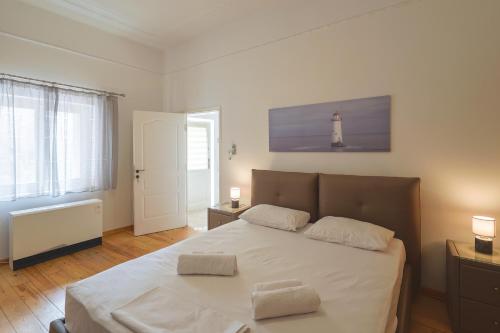 a bedroom with a bed with a lighthouse on the wall at Stenaki - Apartments in Aegina Town in Aegina Town