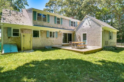 a house with a patio and a table in the yard at 1 Mi to Beach Cape Cod Family Home in Bourne! in Bourne