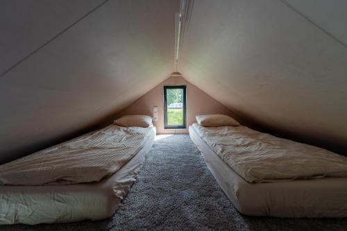 two beds in a room with a window at ORE guest houses in Svenele