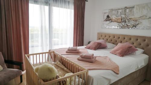 a bedroom with a crib with pink pillows on it at VILLA PAOLA in Polača