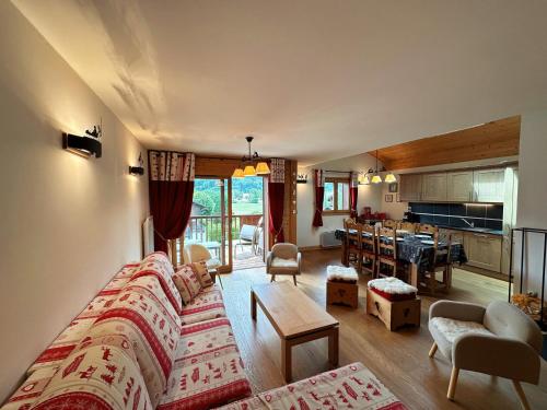un salon avec un canapé et une cuisine dans l'établissement Duplex spacieux avec piscine couverte, balcon et parking, à 300m du centre et proche des pistes - FR-1-624-137, à Samoëns