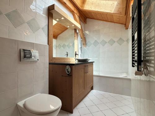 une salle de bain avec toilettes, lavabo et baignoire dans l'établissement Duplex spacieux avec piscine couverte, balcon et parking, à 300m du centre et proche des pistes - FR-1-624-137, à Samoëns