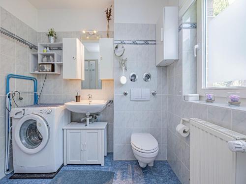 a bathroom with a washing machine and a sink at Ferienwohnung Seebergweg in Maasholm-Bad