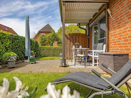 a patio with a table and chairs in a yard at Ferienwohnung Seebergweg in Maasholm-Bad