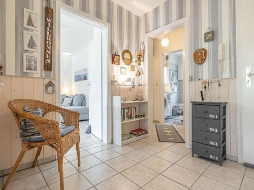 a living room with a chair and a bedroom at Ferienwohnung Seebergweg in Maasholm-Bad