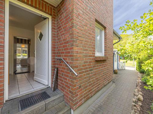 a brick house with a white door and a porch at Ferienwohnung Seebergweg in Maasholm-Bad