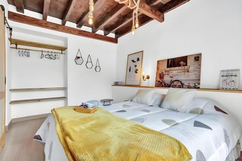 a bedroom with a large white bed with a yellow blanket on it at Casa Los Holandeses in Buenavista del Norte