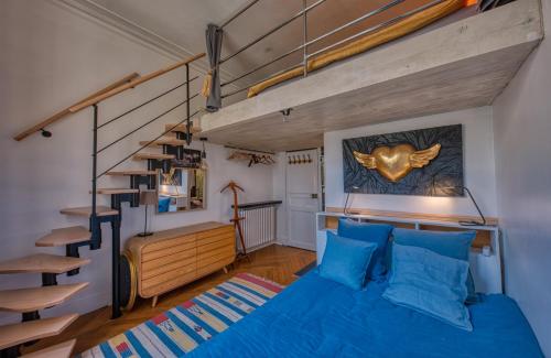 - une chambre avec un lit bleu et un escalier dans l'établissement Chic et décontracté centre de paris, à Paris