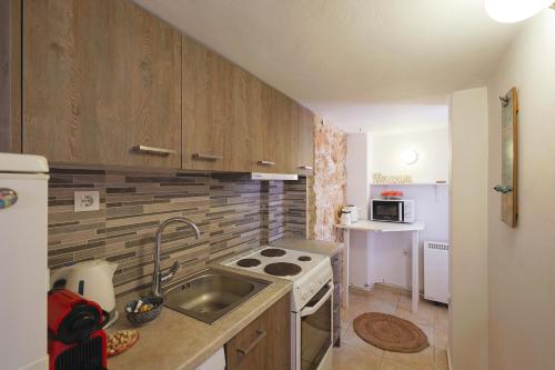a small kitchen with a sink and a stove at Stenaki - Apartments in Aegina Town in Aegina Town