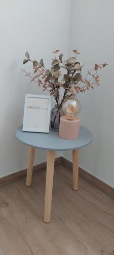 a blue table with a vase of flowers and a box at Irgendwo im Schwarzwald in Elzach