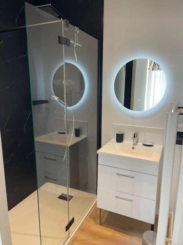 une salle de bain avec une douche en verre et un lavabo dans l'établissement Guérande, appartement de charme Porte Saint-Michel, à Guérande