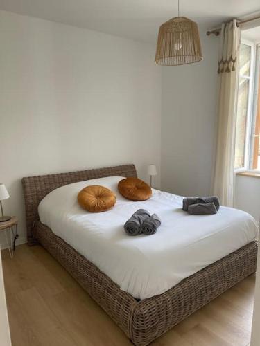 un lit avec deux oreillers dessus dans une chambre dans l'établissement Guérande, appartement de charme Porte Saint-Michel, à Guérande