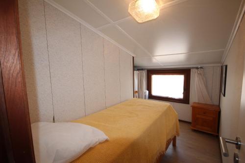 une chambre avec un lit jaune et une fenêtre dans l'établissement Agréable Maison clôturée, DOMAINE TAMARIS, 3 chambres, 6 couchages, Wifi, clim mobile murale, Accès piscines payant, PORTIRAGNES PLAGE LRTAMV12, à Portiragnes