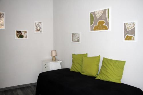sypialnia z łóżkiem z zielonymi poduszkami w obiekcie Le Muse w mieście Brescia