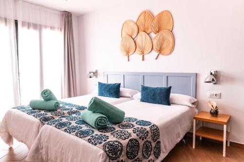 a bedroom with two beds with blue pillows at Los Cardones Boutique Village in Playa de las Americas