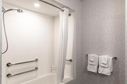 a bathroom with a tub and a shower with towels at Hampton Inn & Suites Charleston-West Ashley in Charleston
