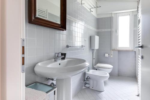 a white bathroom with a sink and a toilet at Residence Diffuso Arcobaleno in Gabicce Mare