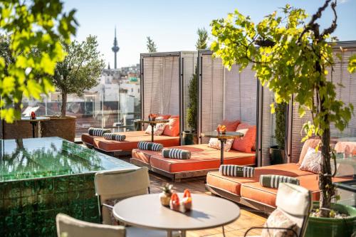 a patio with couches and tables on a roof at BLESS Hotel Madrid - The Leading Hotels of the World in Madrid