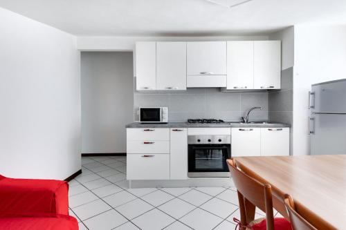 a kitchen with white cabinets and a wooden table at Residence Diffuso Arcobaleno in Gabicce Mare