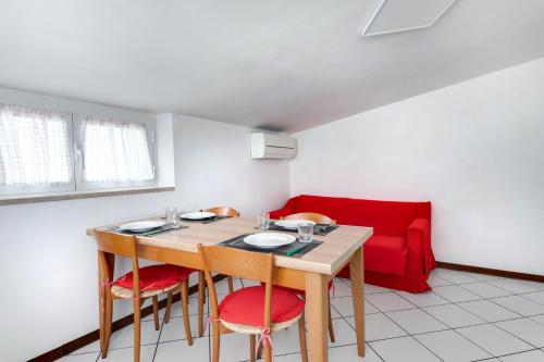 a dining room with a table and chairs and a red couch at Residence Diffuso Arcobaleno in Gabicce Mare