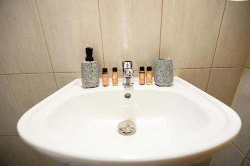 ein weißes Waschbecken im Bad mit Flaschen in der Unterkunft Holiwood in Himarë