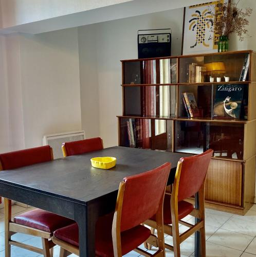 d'une table à manger avec des chaises et une étagère. dans l'établissement Les Toits wifi gratuit Vue cœur de ville historique et Halles, à Béziers