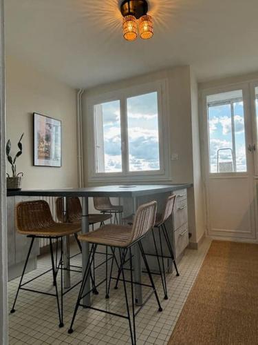 - une salle à manger avec des chaises, une table et des fenêtres dans l'établissement Les alouettes, à Aurillac