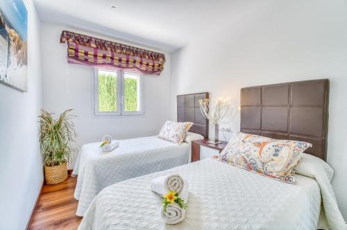 een slaapkamer met twee bedden en een raam bij Ideal Property Mallorca - Xiscama in Alcudia