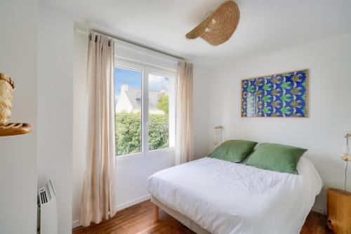 une chambre blanche avec un lit et une fenêtre dans l'établissement Jolie maison pour 4 - 300m plage et etang, à l'Île-Tudy