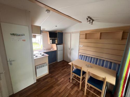 une petite cuisine et salle à manger avec une table et des chaises dans l'établissement Les Pinots d'Alsace - 3 bungalows climatisés avec TV - Proche Europa Park, à Boofzheim
