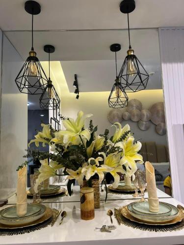 a dining room table with yellow flowers and chandeliers at DonRio Hotel Siquijor in Siquijor