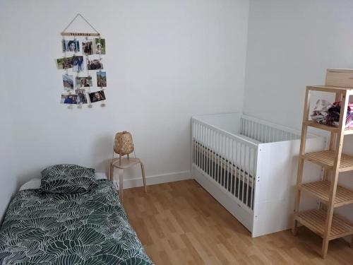 - une chambre bébé avec un lit bébé et une chaise haute dans l'établissement Charmant T5 en pleine nature à Viroflay-Versailles, à Viroflay