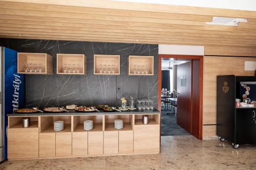 a restaurant with a counter with food on it at Airport Hotel Budapest in Vecsés