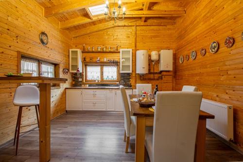 a kitchen with wooden walls and a table and chairs at Cabanele Sașilor in Cisnadioara