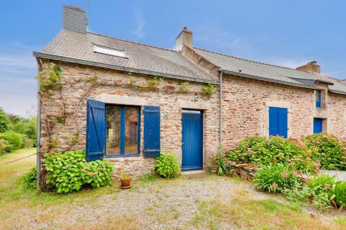 une maison en briques avec des fenêtres et des volets bleus dans l'établissement Jolie maison pour 5 sur la presqu ile de Rhuys, à Le Tour-du-Parc
