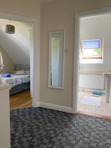 a room with a mirror and a bedroom with a bed at Blacklion Holiday Homes in Blacklion