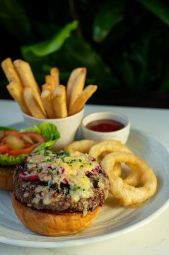 a plate of food with a burger and onion rings at The Cellars-Hohenort in Cape Town
